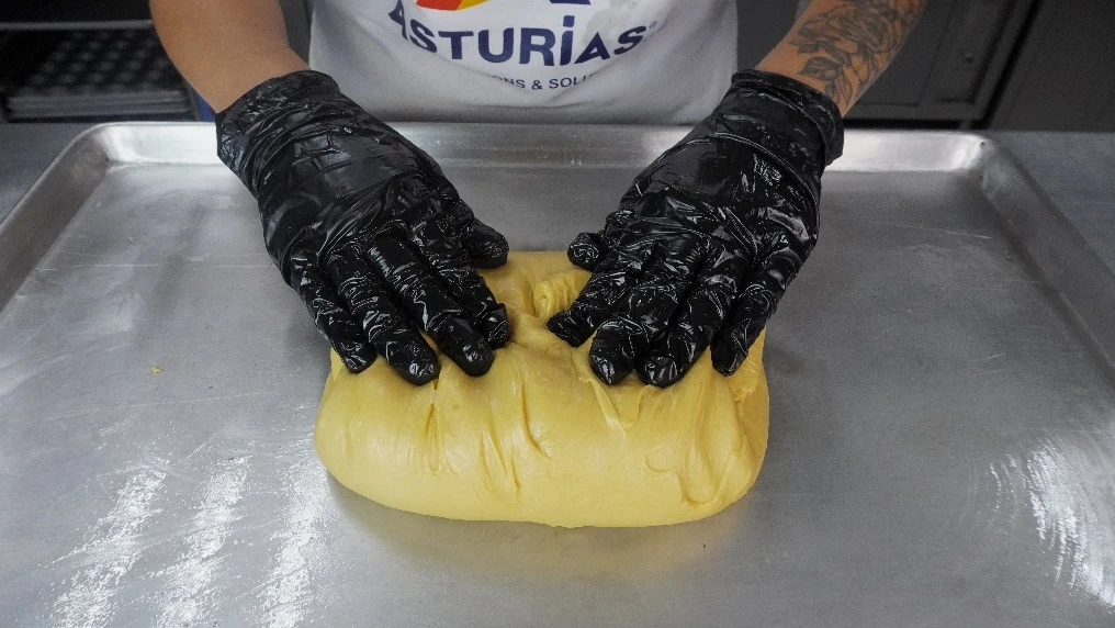 Acomodo de la masa en una charola para el reposo